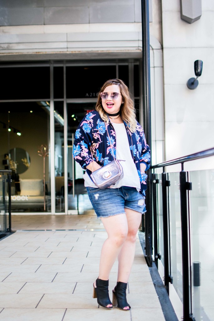 Accessorize dsitressed denim shorts and a floral bomber jacket for an edgy and feminine look. 